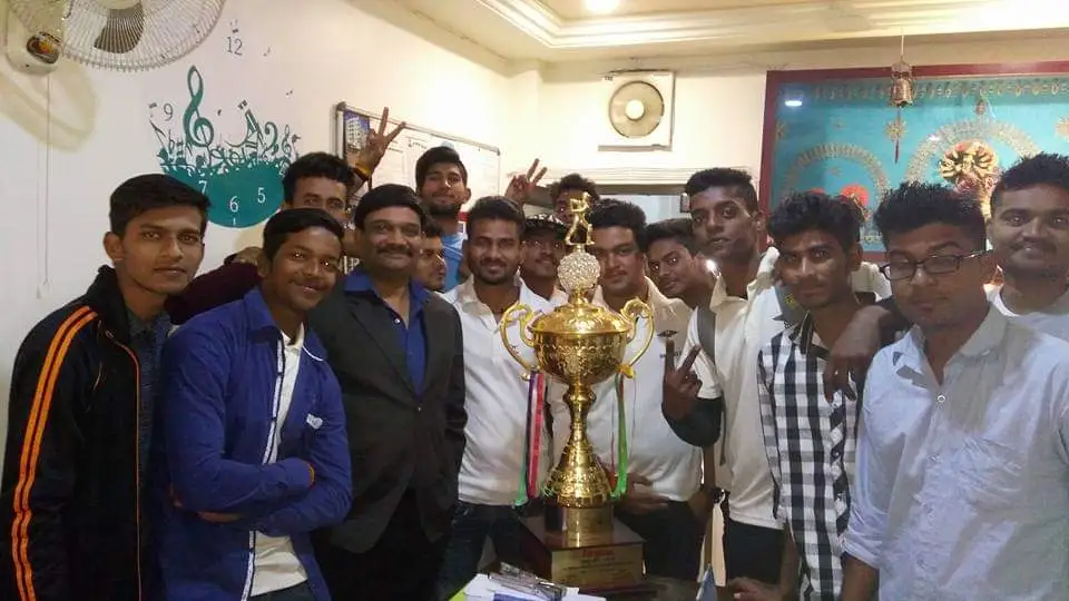 People standing around a Gold trophy.