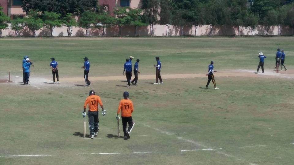 Photograph containing players getting ready for a cricket match.