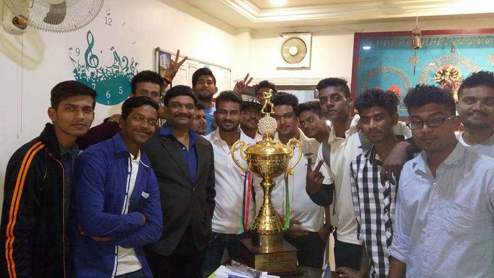 People standing around a gold trophy.