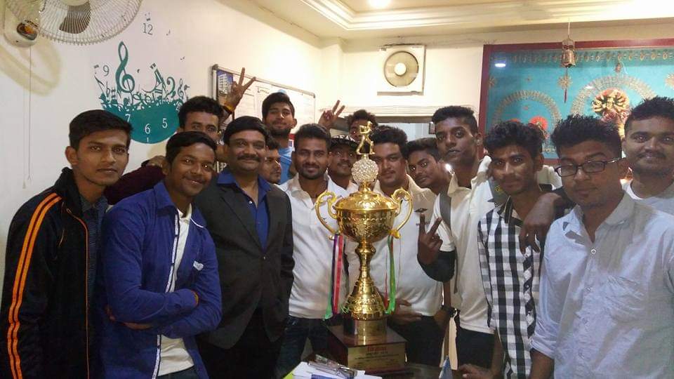 People standing around a gold trophy.